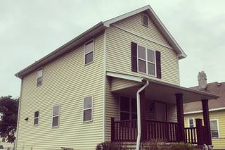 A Milwaukee house with a covered porch, seen from the side.